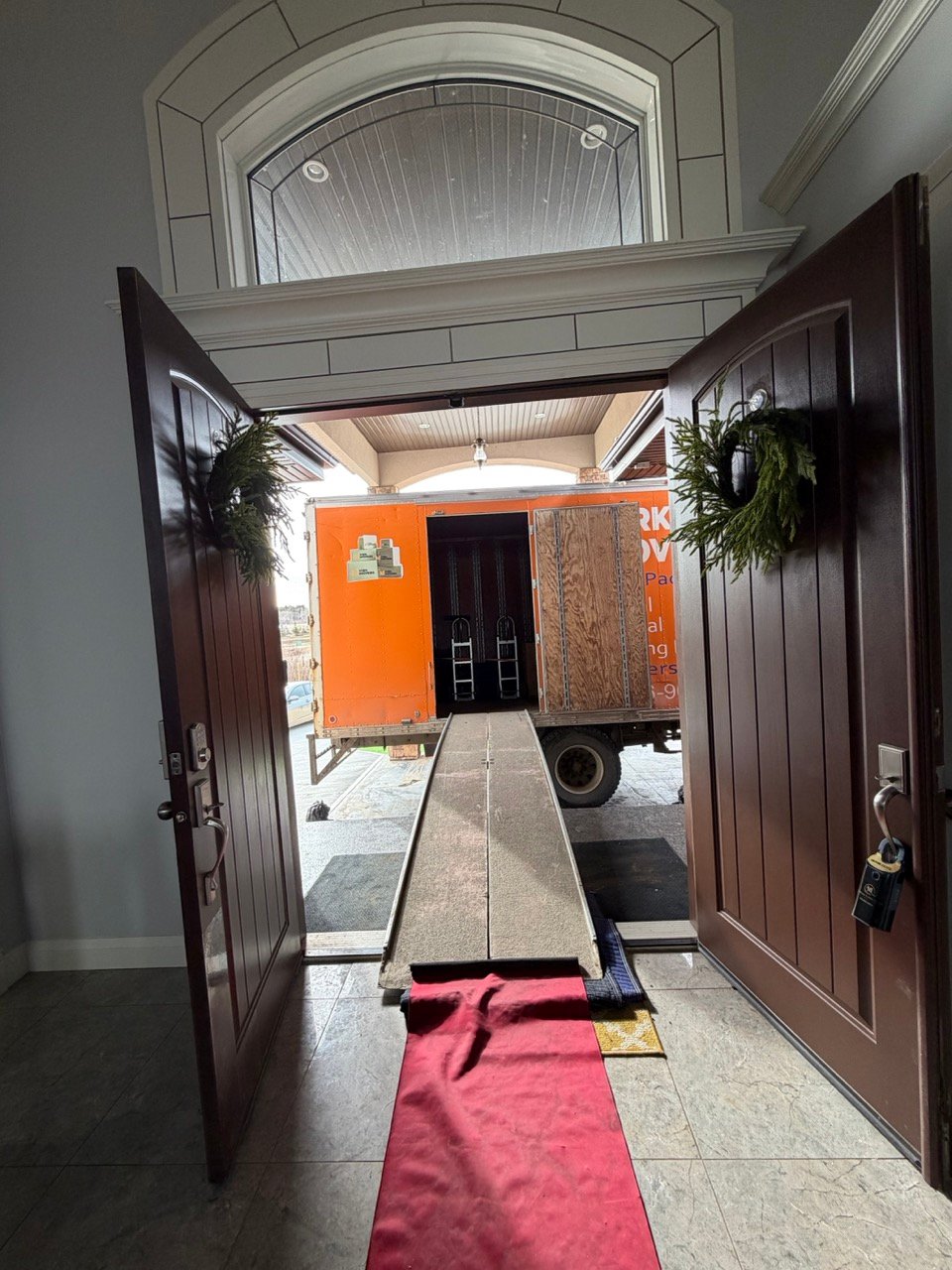 Moving truck ramp set up at a home entrance to provide a clear path for loading household items during a residential move